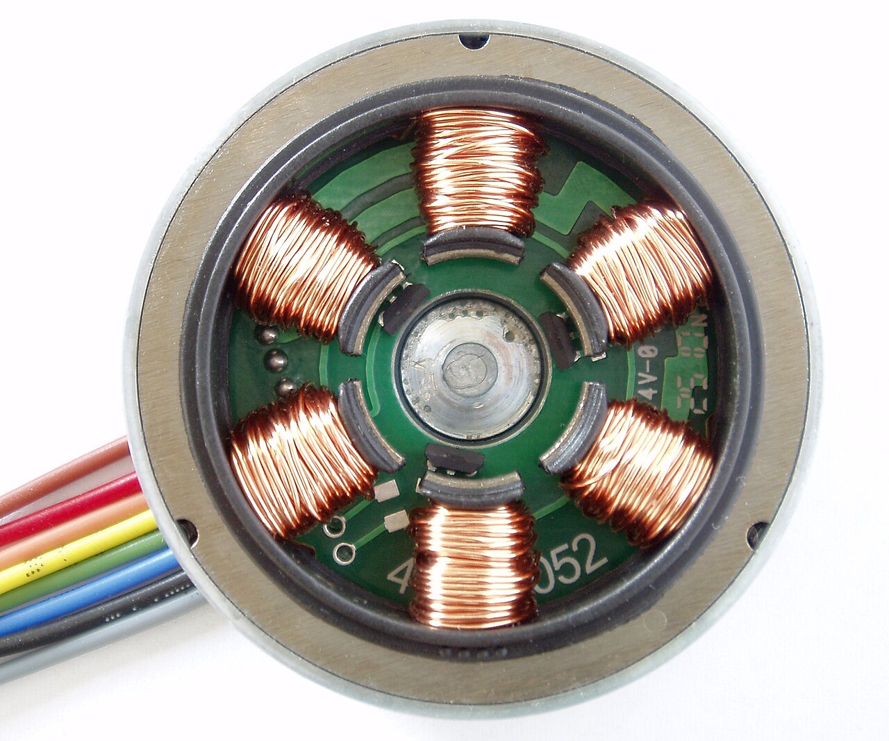 The exposed stator of a brushless DC motor, showing copper wire wound around the slots.